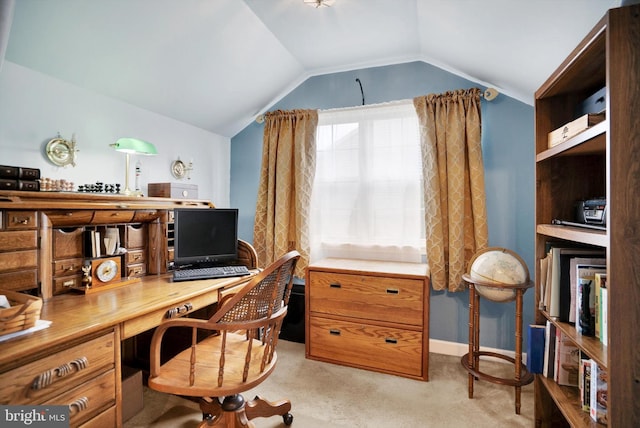 office featuring vaulted ceiling, built in desk, and light colored carpet