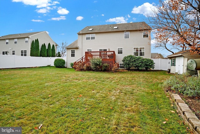 back of property featuring a wooden deck and a yard