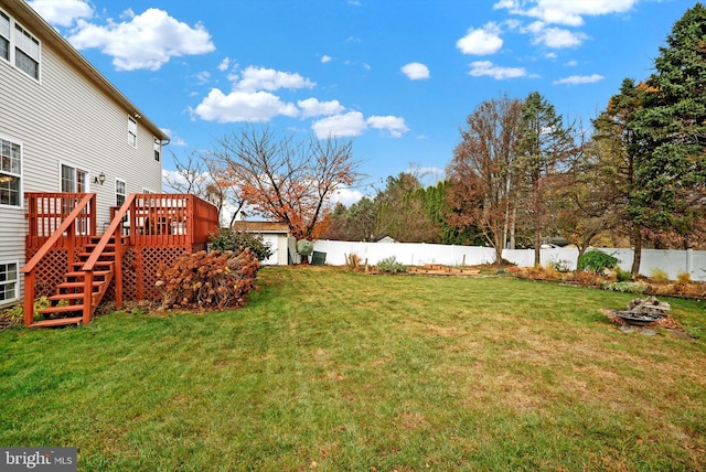 view of yard with a deck and a fire pit