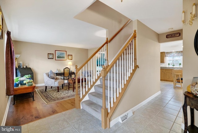 stairway with tile patterned floors and sink