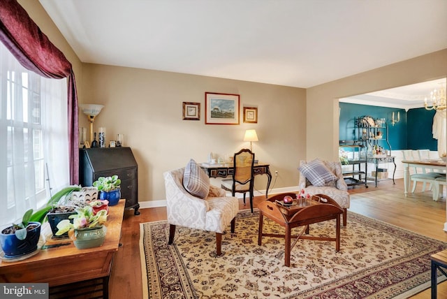 sitting room with hardwood / wood-style floors, a chandelier, and a healthy amount of sunlight