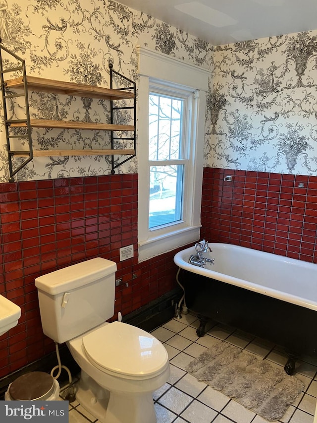 bathroom featuring toilet, tile patterned flooring, and a bathing tub