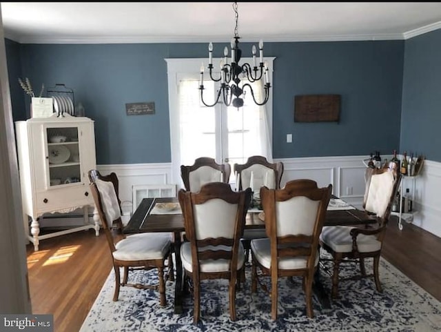 dining area with a chandelier, crown molding, and hardwood / wood-style flooring