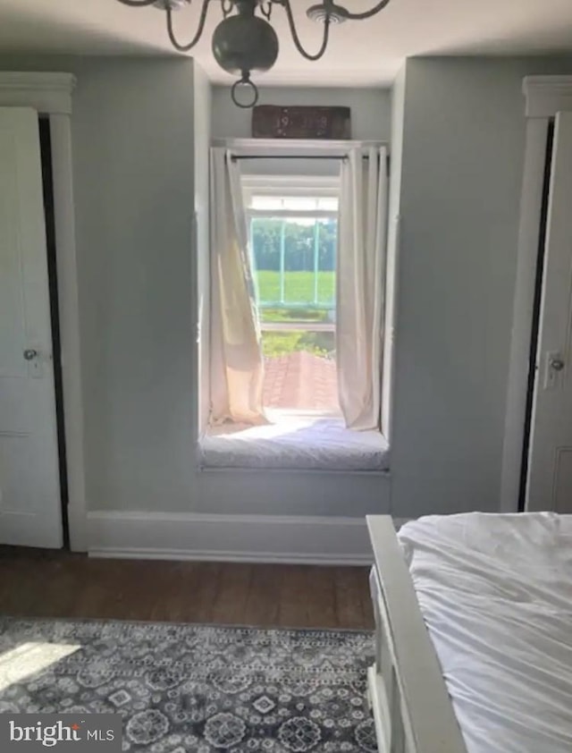 bedroom featuring dark hardwood / wood-style floors and a notable chandelier