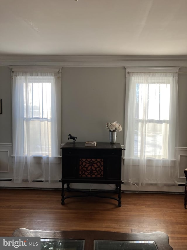 sitting room with hardwood / wood-style floors, crown molding, and plenty of natural light