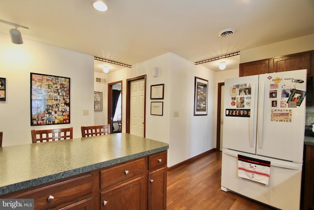 kitchen featuring rail lighting, white refrigerator, and dark wood-type flooring