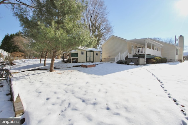 snow covered property featuring a shed