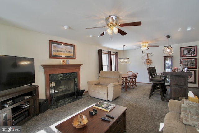 living room featuring a premium fireplace, carpet, and ceiling fan