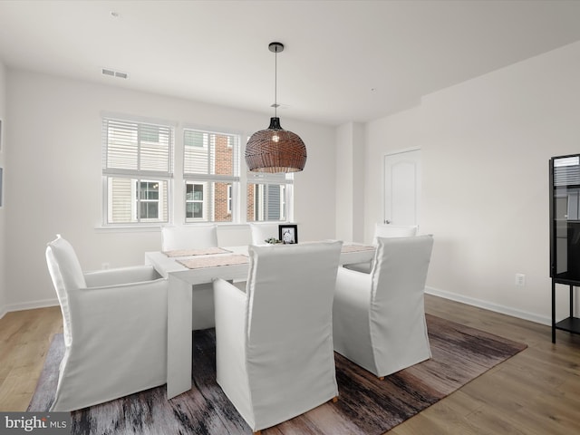 dining room with visible vents, baseboards, and wood finished floors