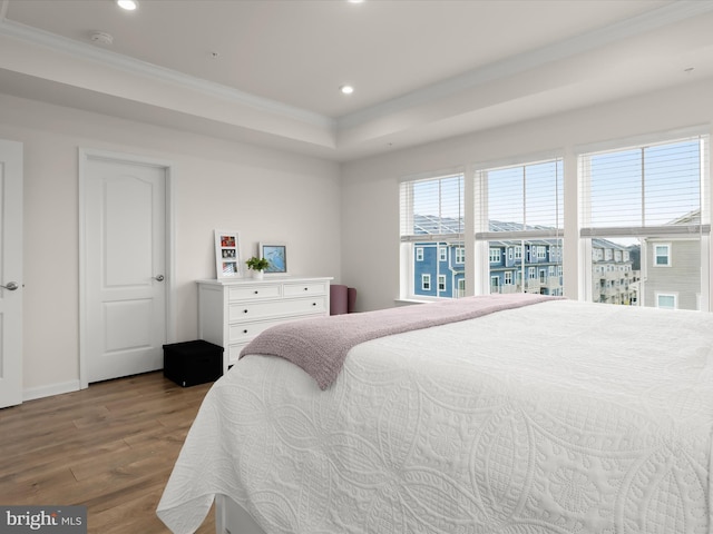 bedroom with recessed lighting, baseboards, wood finished floors, and crown molding