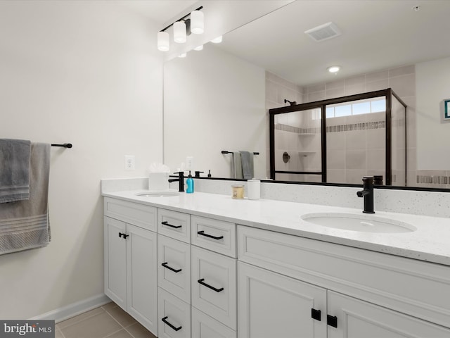 full bathroom featuring a shower stall, visible vents, tile patterned floors, and a sink