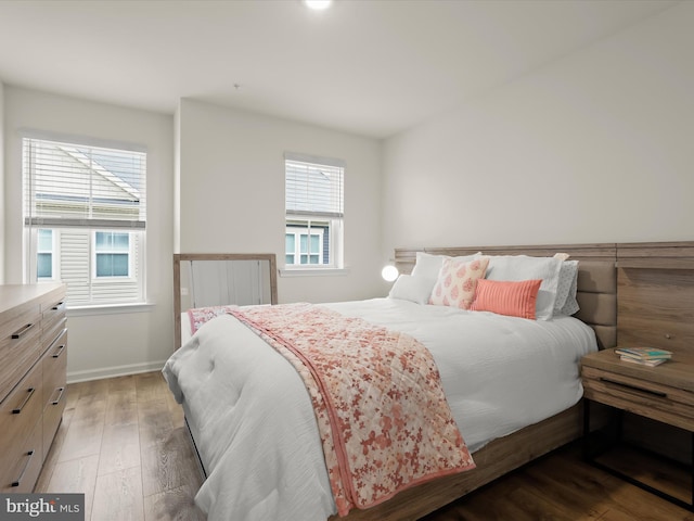 bedroom featuring baseboards and light wood finished floors