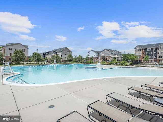 community pool with a patio area and a residential view