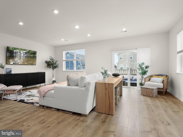 living area featuring a wealth of natural light, visible vents, recessed lighting, and light wood finished floors