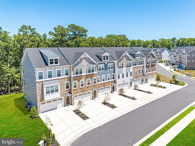 townhome / multi-family property with a garage, a front yard, and central AC