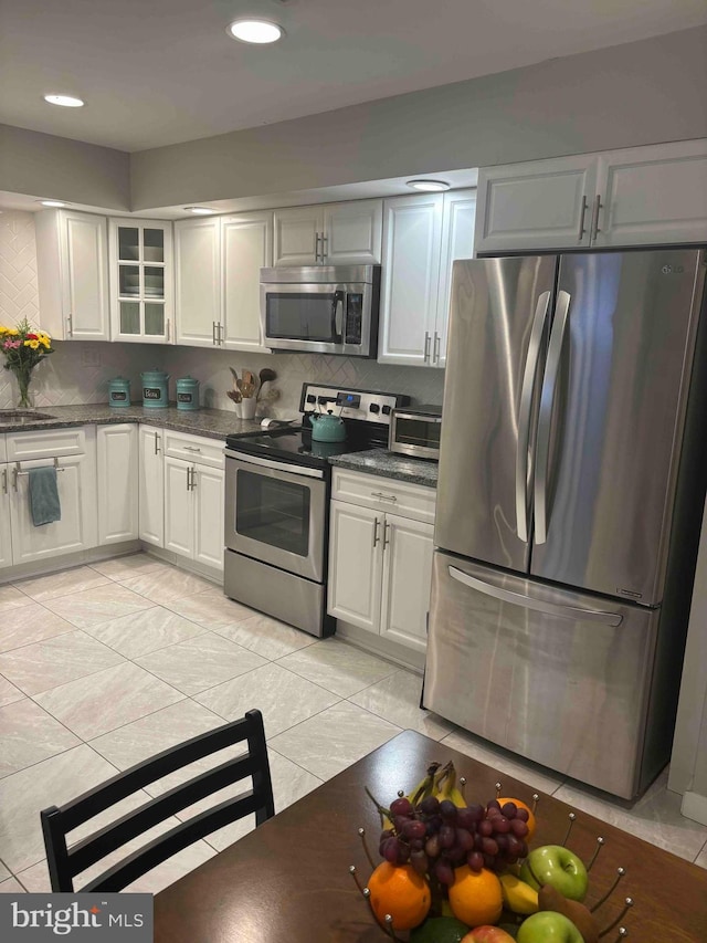 kitchen with sink, appliances with stainless steel finishes, tasteful backsplash, and white cabinetry