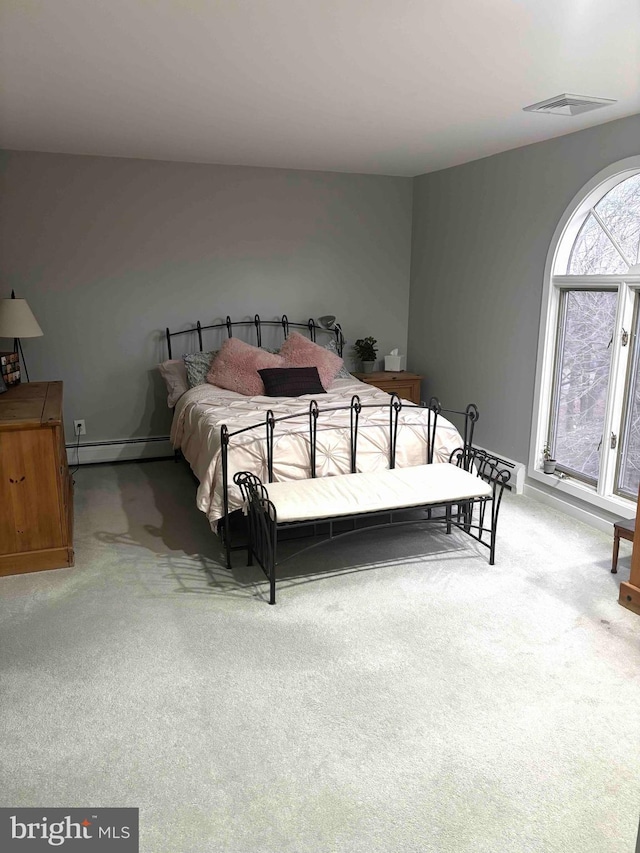 carpeted bedroom featuring a baseboard heating unit