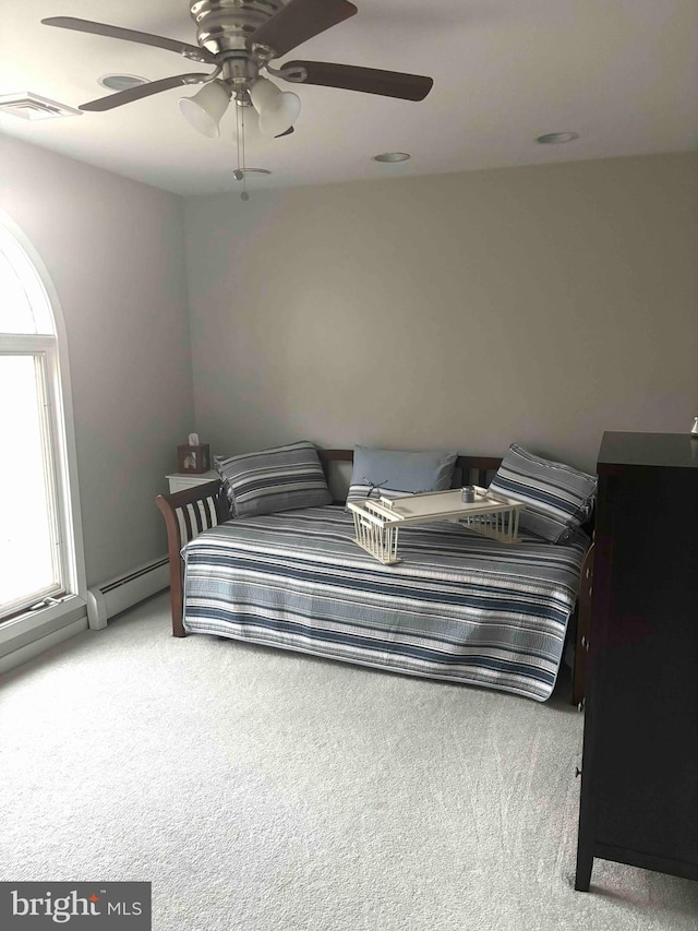 carpeted bedroom with ceiling fan and baseboard heating