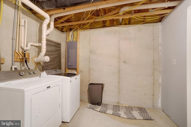 clothes washing area with electric panel and separate washer and dryer