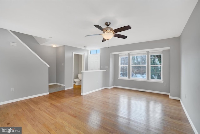 unfurnished living room featuring ceiling fan and light wood-type flooring