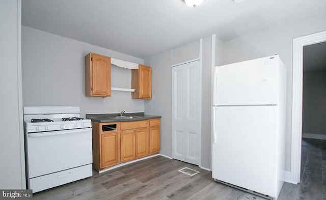 kitchen featuring white appliances, dark hardwood / wood-style floors, and sink