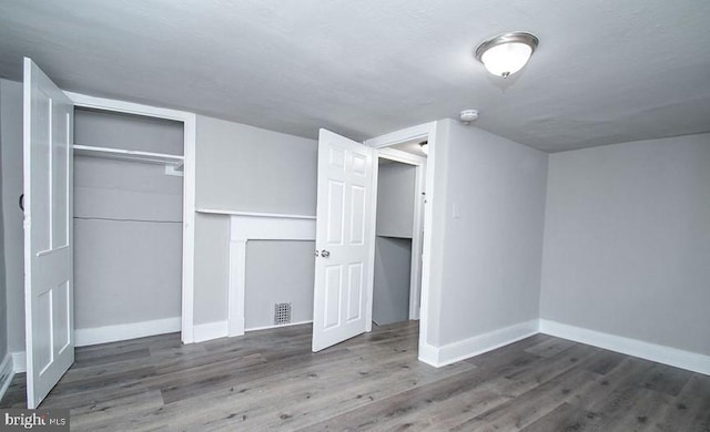 unfurnished bedroom with a closet and hardwood / wood-style flooring