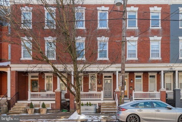 townhome / multi-family property featuring covered porch