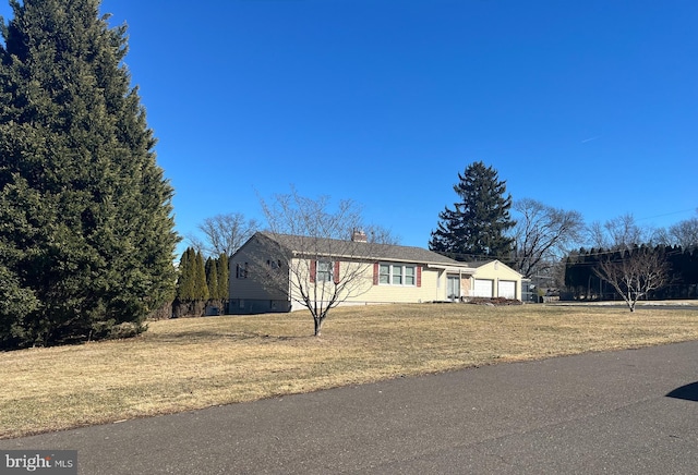 single story home featuring a garage and a front yard