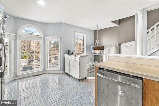 kitchen featuring light tile patterned floors, white cabinetry, dishwasher, and hanging light fixtures