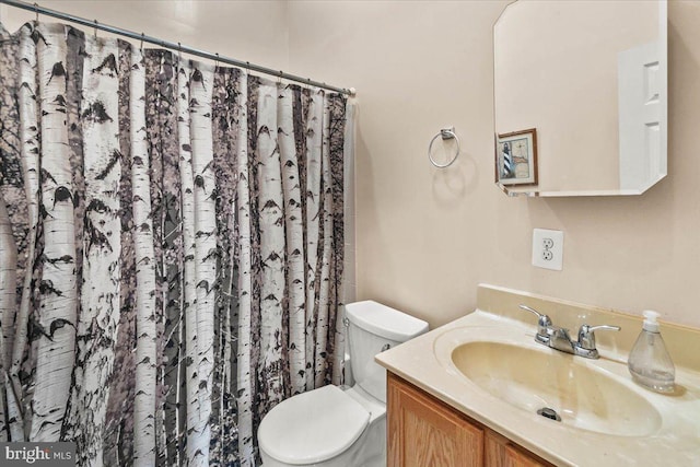 bathroom with toilet, vanity, and a shower with shower curtain