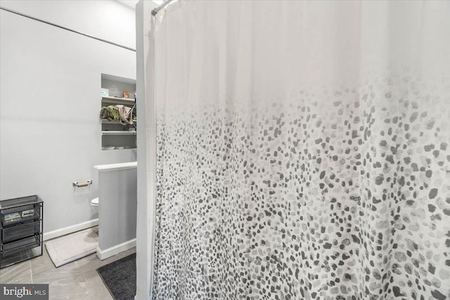 bathroom featuring toilet and a shower with shower curtain