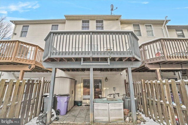 snow covered house with a wooden deck