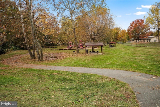 view of community featuring a playground and a lawn