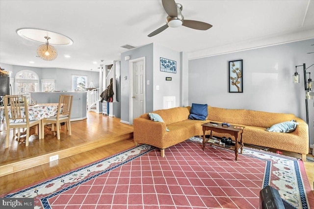 living room with wood-type flooring and ceiling fan