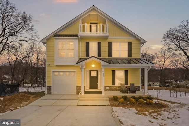 view of front of home featuring a garage, a balcony, and a porch