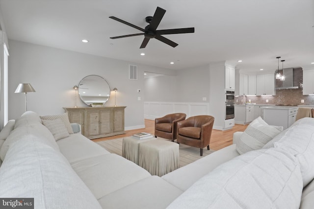 living room featuring ceiling fan and light wood-type flooring