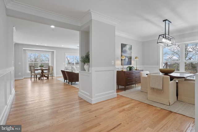 dining space featuring ornamental molding and light wood-type flooring