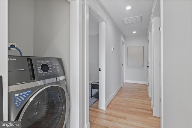 clothes washing area featuring light wood-type flooring and washer / clothes dryer