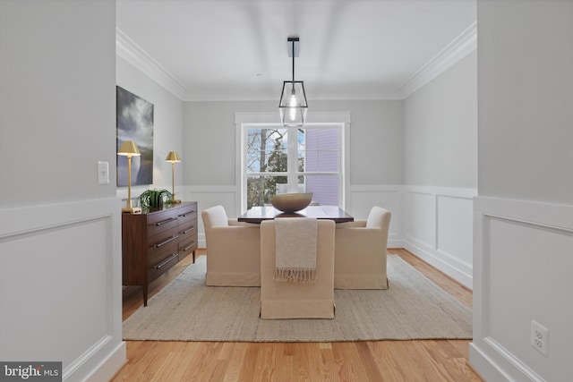 dining space featuring ornamental molding and light wood-type flooring