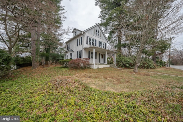 view of front of home with a front yard and covered porch