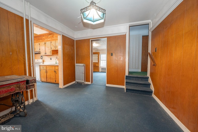 interior space with radiator, wooden walls, sink, and crown molding