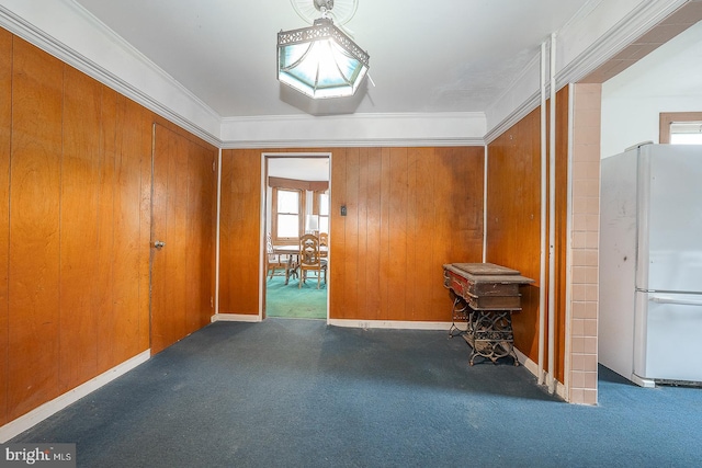 hallway featuring ornamental molding, wooden walls, and dark colored carpet