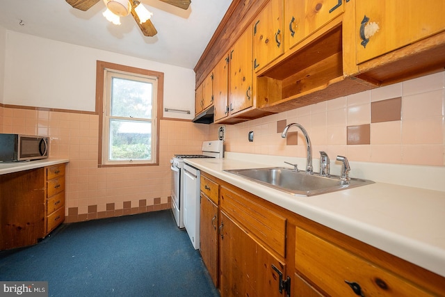 kitchen with white appliances, ceiling fan, tile walls, and sink