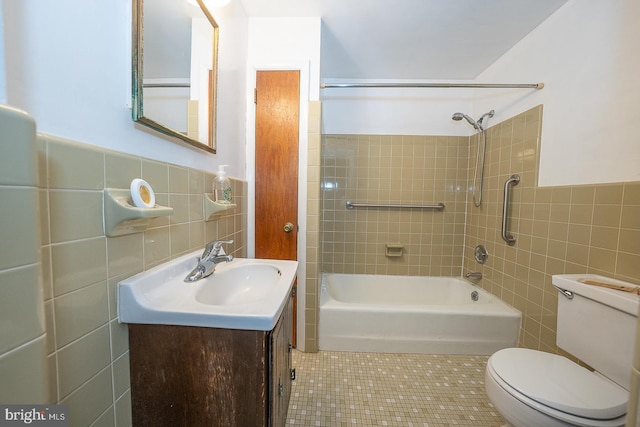 full bathroom featuring tiled shower / bath, tile walls, toilet, tile patterned floors, and vanity