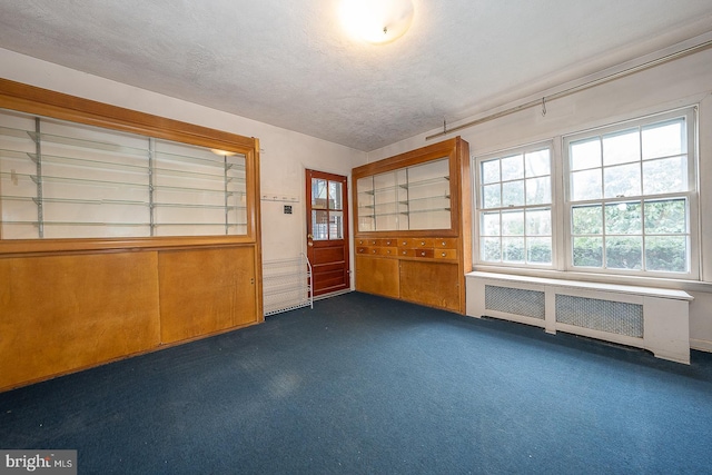 interior space with a textured ceiling and radiator