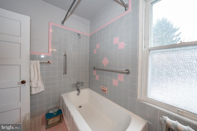 bathroom featuring tile walls, plenty of natural light, and tiled shower / bath