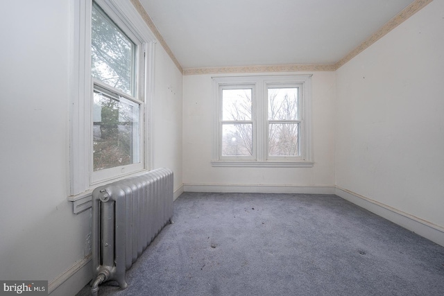 carpeted spare room featuring radiator heating unit