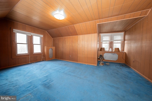 additional living space with wooden walls, wooden ceiling, carpet, and vaulted ceiling