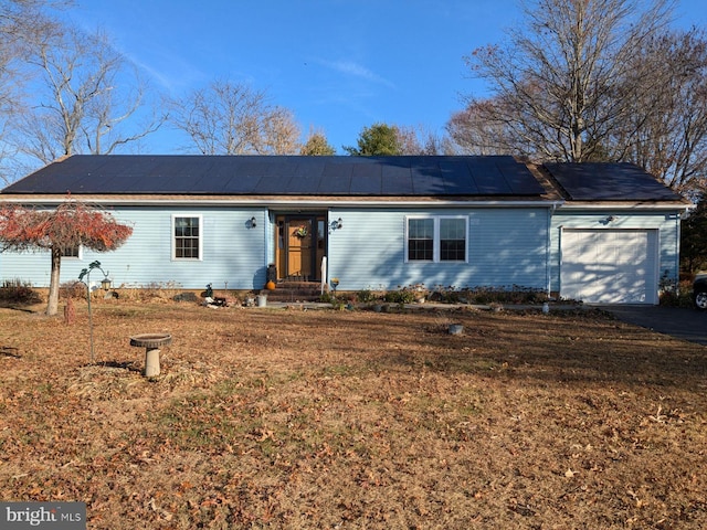 ranch-style house featuring solar panels and a garage