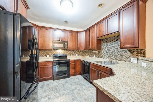 kitchen featuring light stone countertops, sink, decorative backsplash, and black appliances